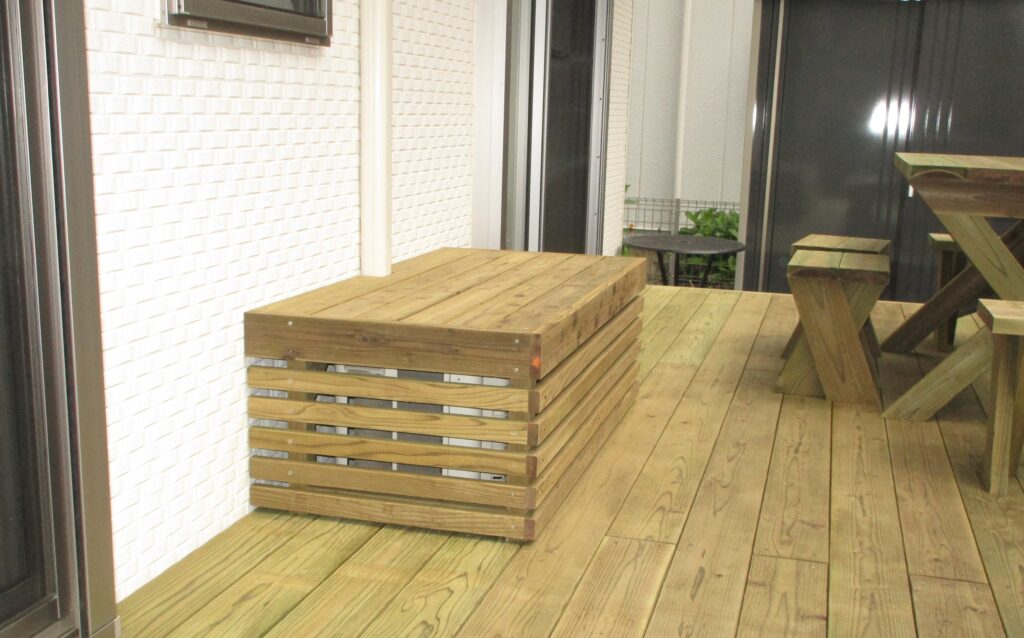 ウッドデッキ上の木製室外機カバーはベンチにもなるほどしっかりしています。腐りにくい処理を施した材木を使用しています。横浜市