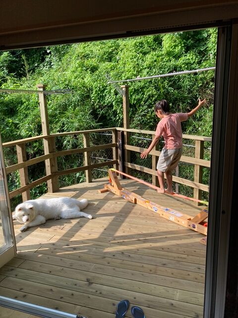 お手入れ簡単で長持ちする木製バルコニーで遊ぶお嬢ちゃんとムクムクのワンコ　鎌倉素