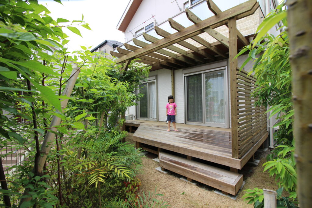 ウッドデッキとパーゴラとフェンスと女の子と植物　長持ちデッキ加圧注入材