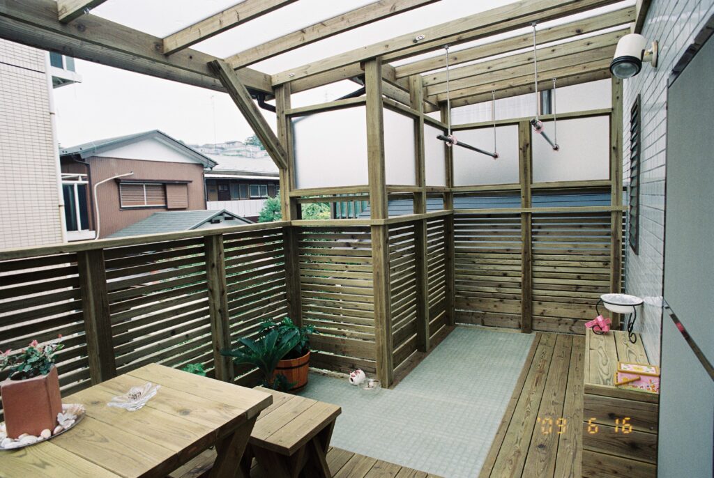 屋根とフェンスにポリカーボネイト平板を使った木製バルコニー　FRPベランダ材　腐りにくい木材での施工例　中原区
