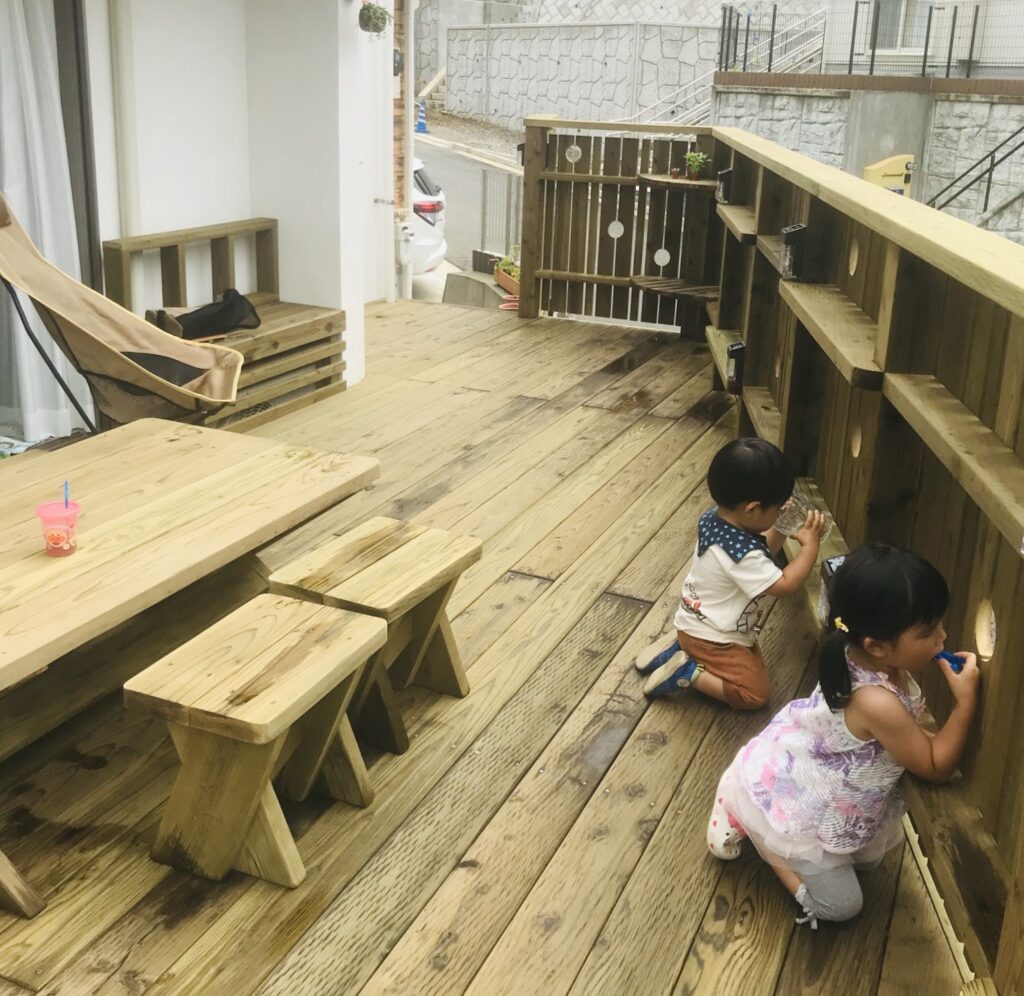 長持ちする木製バルコニのフェンスの穴から外を覗く子供達　横浜市都筑区