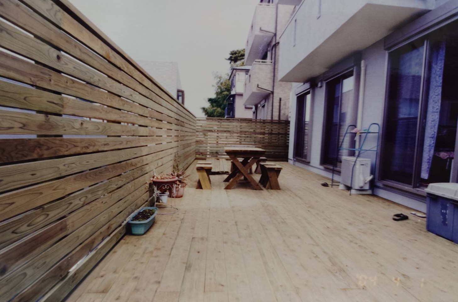 斜面地の上に平らな庭ができ、更に高いウッドフェンス、海老名市